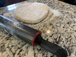 Grandma's Homemade Biscuits 3 Dough for Grandma's homemade biscuits with rolling pin on granite countertop.